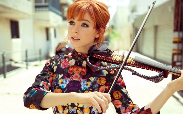 Lindsey Stirling plays a decorated violin outdoors