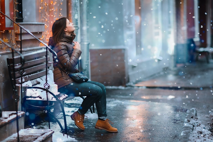 Woman sitting on a bench in the snow