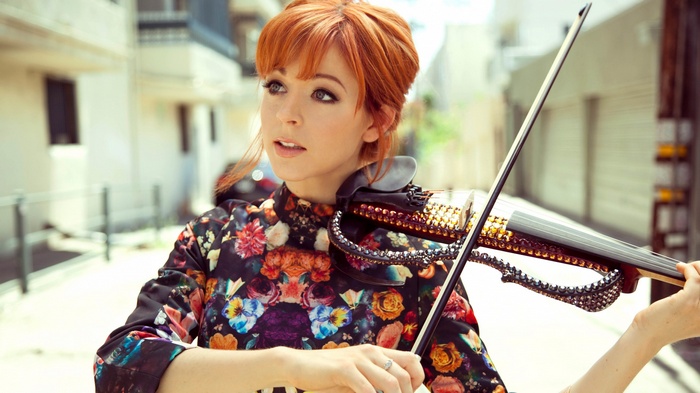Lindsey Stirling plays a jeweled electric violin outdoors