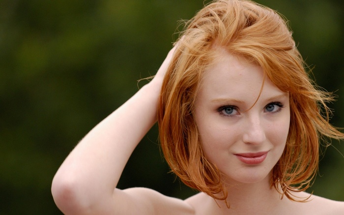 Clelia, a redhead woman with blue eyes