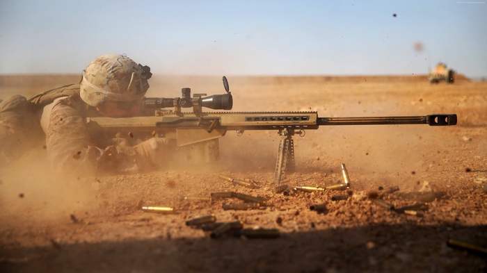 Soldier firing a Barrett M82 A1 sniper rifle in the desert