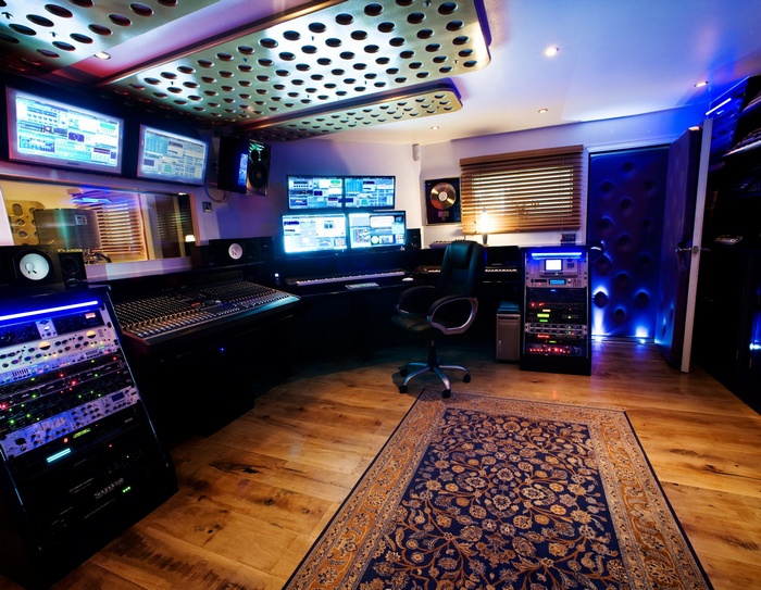Recording studio with mixing console and multiple monitors