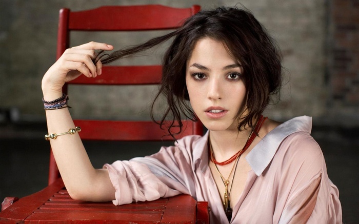 Olivia Thirlby sitting on a red chair
