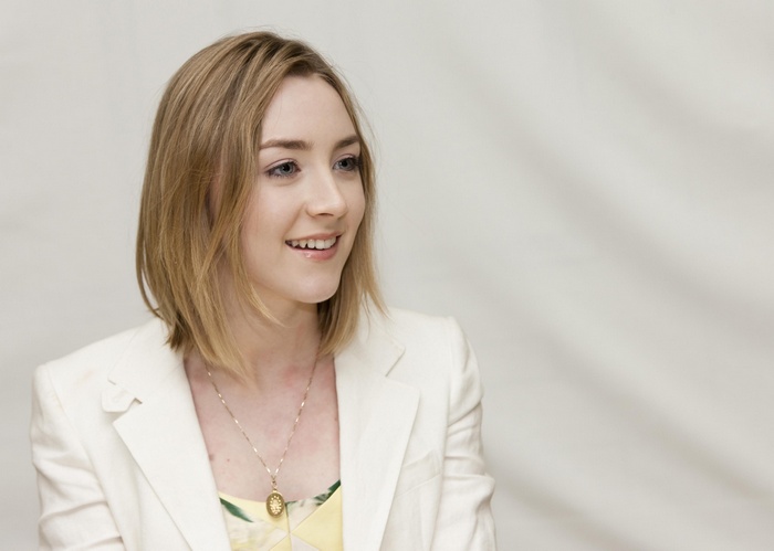 Saoirse Ronan smiles wearing a white blazer