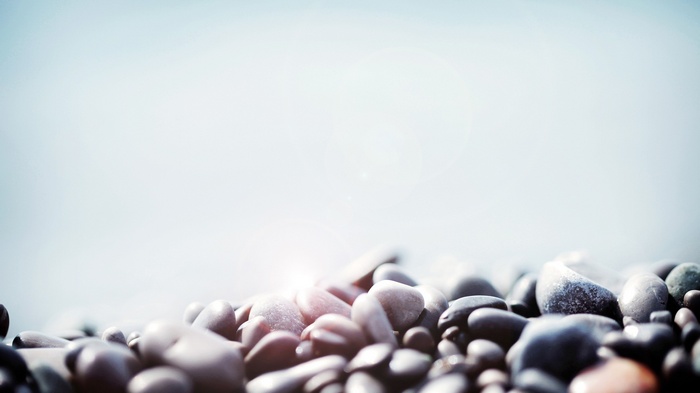 Pebbles on a beach with a bright sky