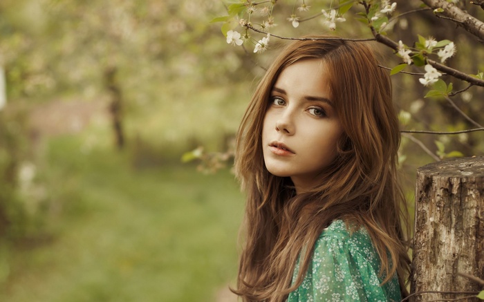 Woman with brown hair in a green dress outdoors