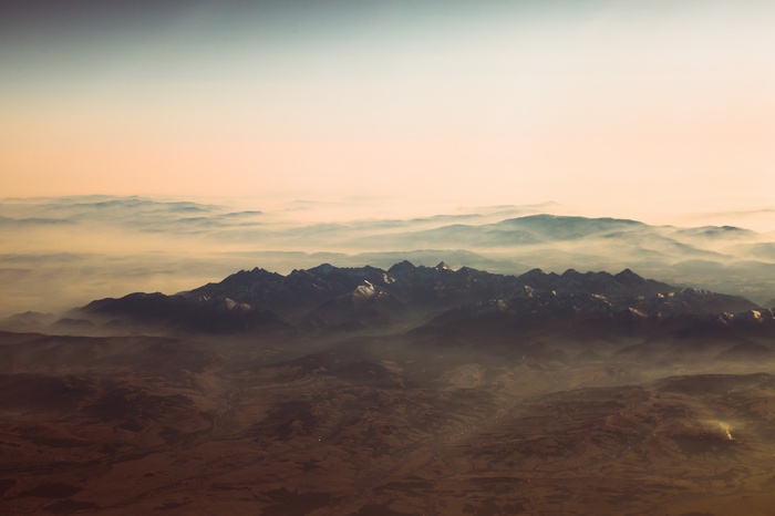 Aerial view of misty mountains at sunset