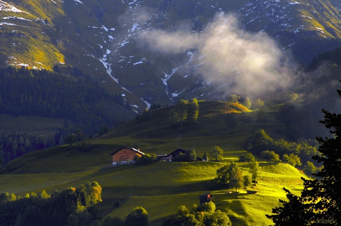 Alpine landscape with cabins and misty mountains in Austria