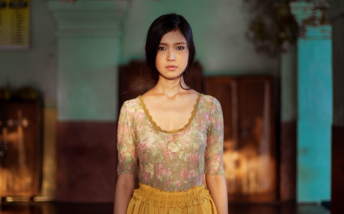 Asian woman in floral top and yellow skirt
