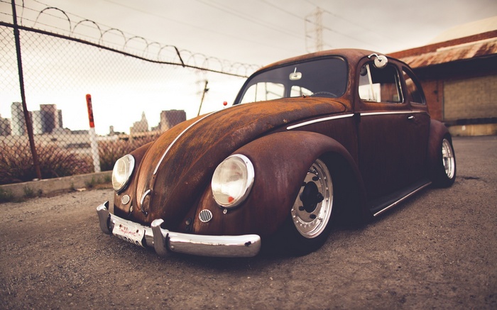 Rusty Volkswagen Beetle parked on asphalt