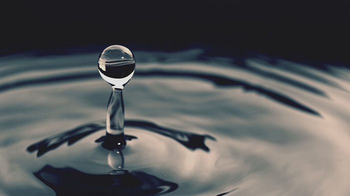 Macro shot of a water drop creating ripples
