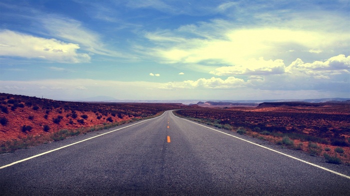 Desert road under a cloudy sky