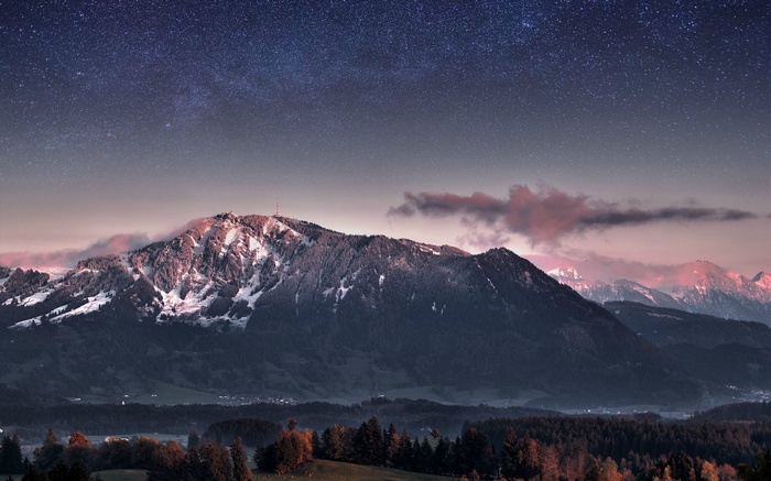 Starry night over snow-capped mountains