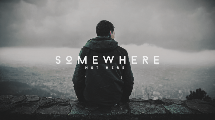 Man sitting on a wall overlooking a city