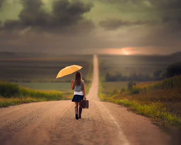 Woman with umbrella and suitcase on Nebraska road