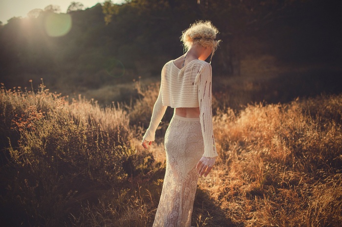 Woman with blonde curly hair in white clothing outdoors