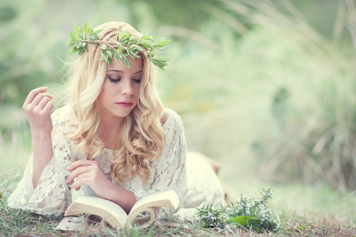 Woman with a wreath reading a book outdoors