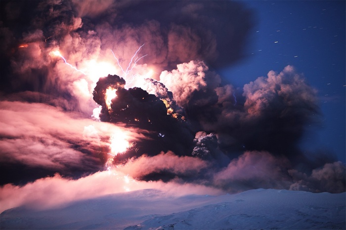 Volcanic eruption with lightning strikes over snowy landscape