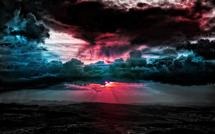 Dramatic sunset over a dark landscape with colorful clouds