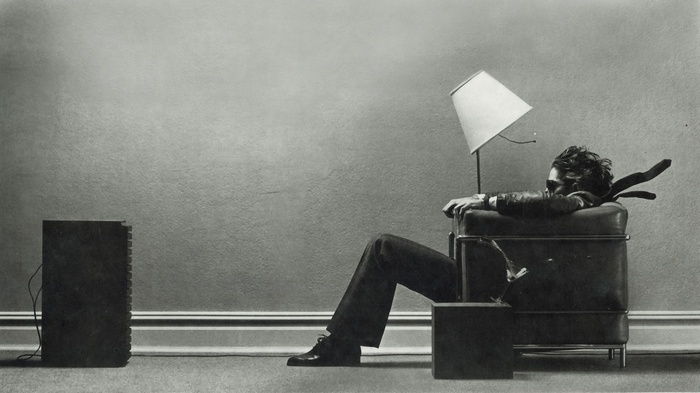 Man with lamp for head sitting in chair