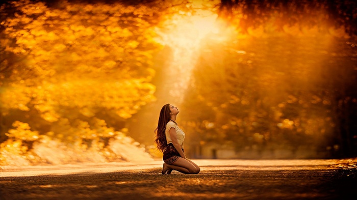 Woman kneeling in sunlight outdoors