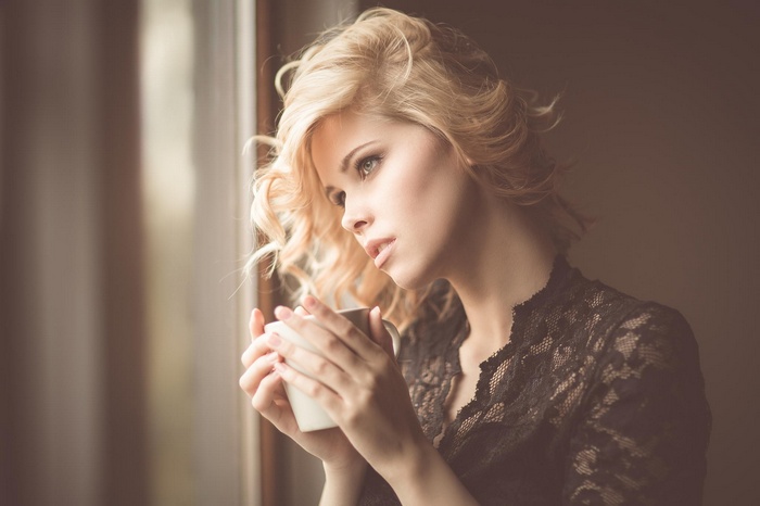 Woman with blonde curly hair holding a mug
