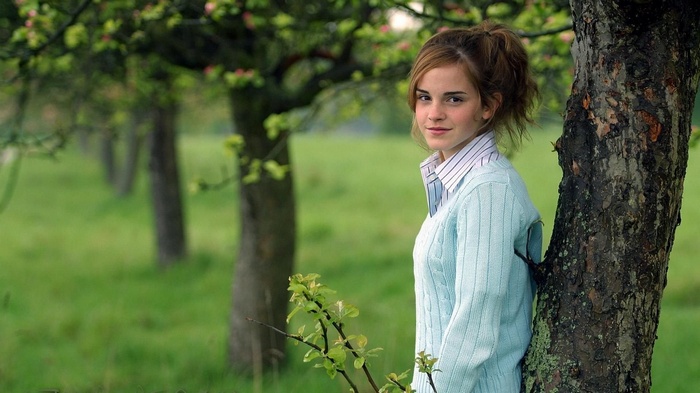 Emma Watson leaning against a tree