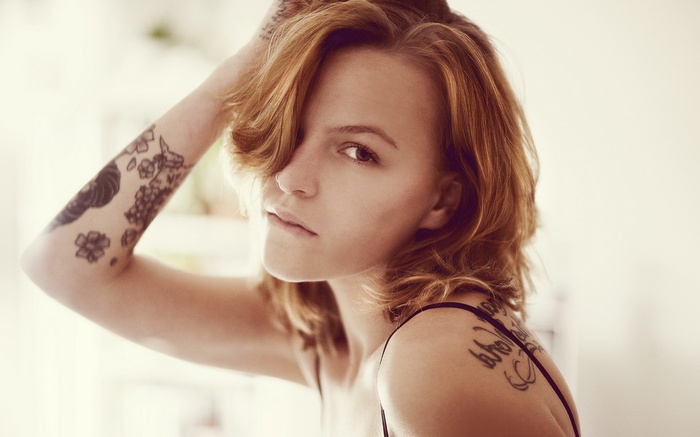 Woman with tattoos on her arm and shoulder