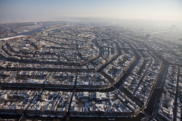 Amsterdam cityscape covered in snow during winter, aerial view