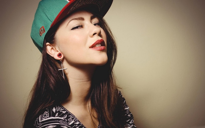Woman wearing a green hat and cross earring
