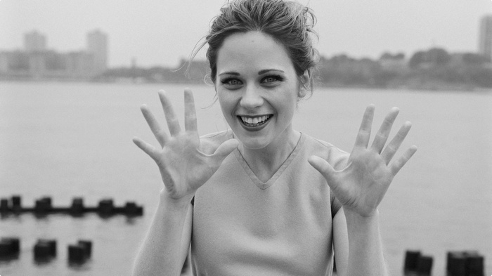 Zooey Deschanel smiling and holding up her hands