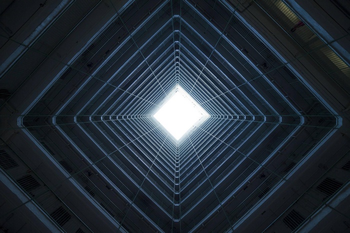Symmetrical building interior looking up at the sky
