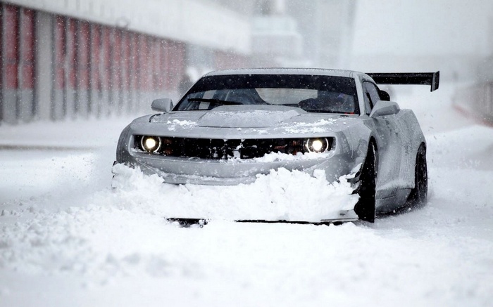 Silver Chevrolet Camaro driving through snow