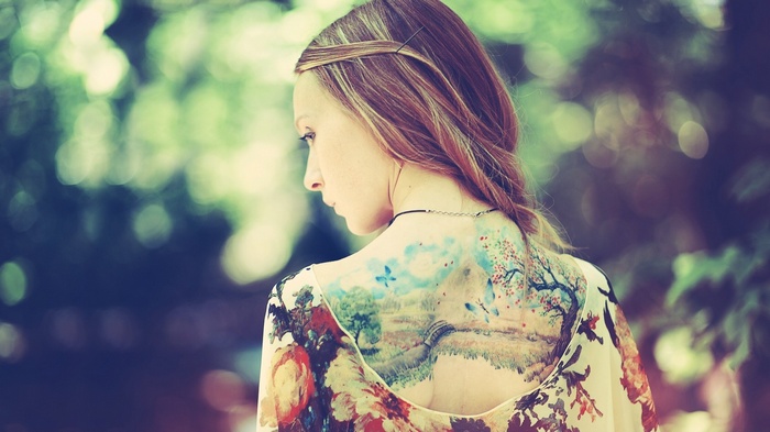 Woman with a large landscape tattoo on her back