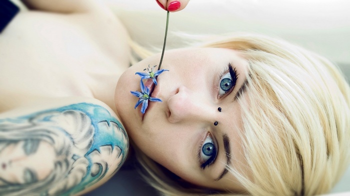 Woman with blonde hair and blue eyes and tattoos
