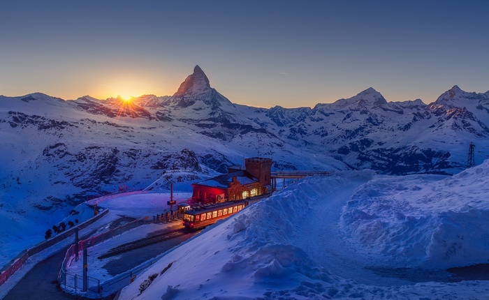 Sunset over the Matterhorn with a train station and train