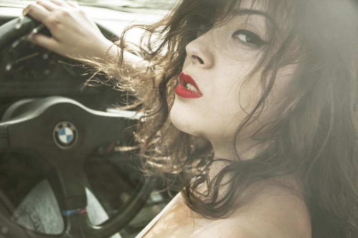 Woman with red lipstick driving a BMW