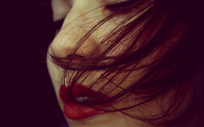 Woman with red lipstick and hair covering face