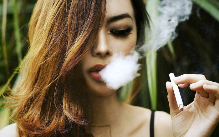 Woman smoking a cigarette with smoke coming from her mouth