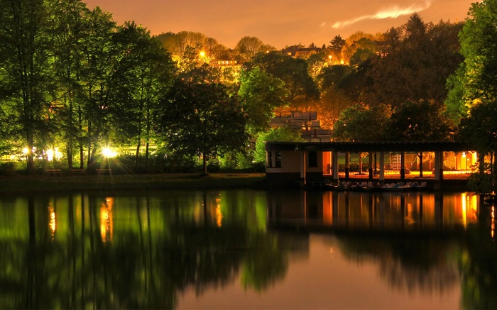 Lake with illuminated building and trees at dusk