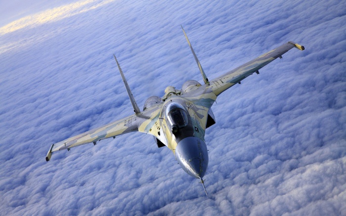Sukhoi Su-37 jet fighter flying over clouds