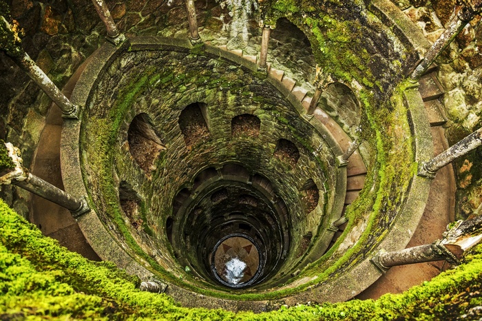 Mossy stone spiral well with stairs