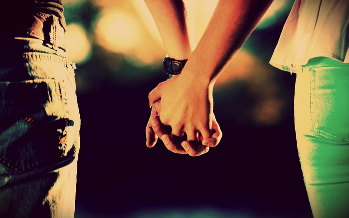 Couple holding hands outdoors at night