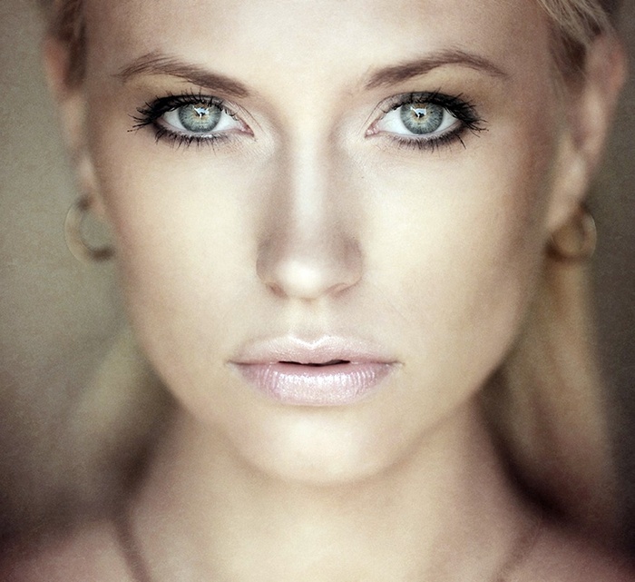 Close-up portrait of a blonde woman with green eyes