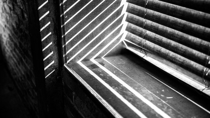 Monochrome photography of sunlight through blinds on a window sill