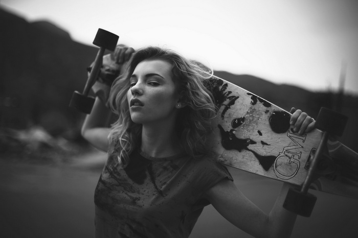 Monochrome portrait of a woman with a longboard