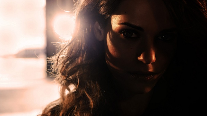 Lyndsy Fonseca with long brunette hair and backlighting