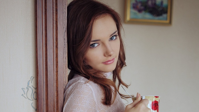 Woman with blue eyes holding a cup