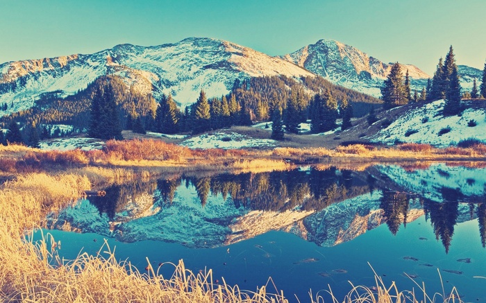 Snow-capped mountains reflected in a calm lake