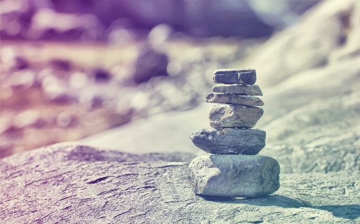 Stack of balanced rocks on a textured surface